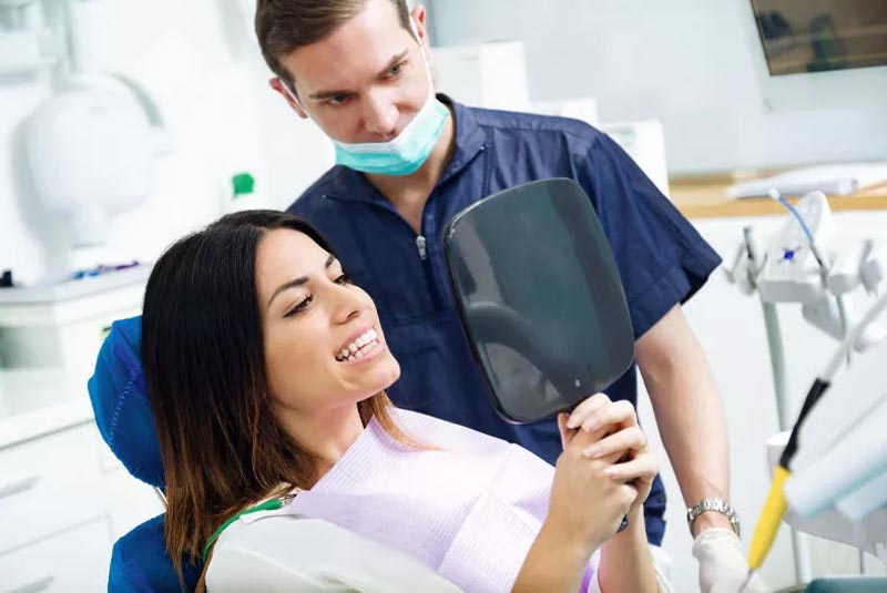 a dental implant surgery patient smiling after successfully getting dental implants